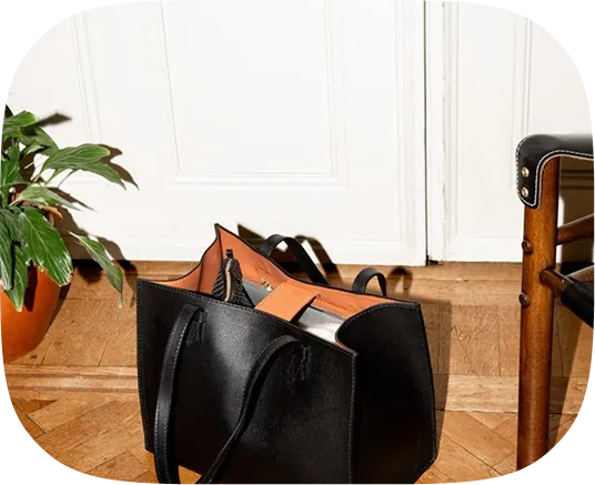 A black purse sitting on top of a wooden floor.
