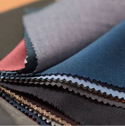 A pile of different colored fabrics on a table.