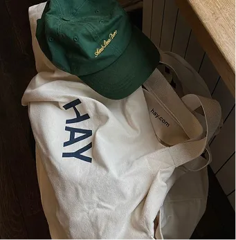 A white bag with a green hat on top of it.